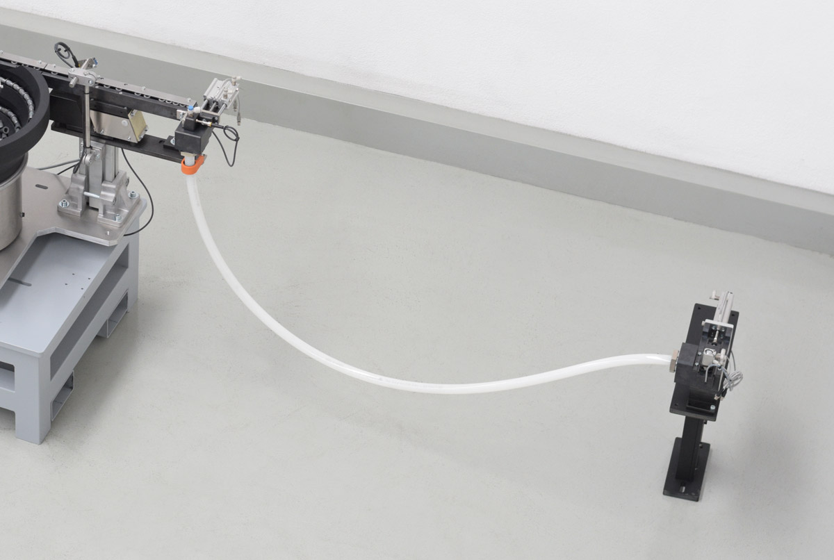 Sistema industrial de posicionamiento automatizado de piezas: tuercas emachables vista superior salida de piezas