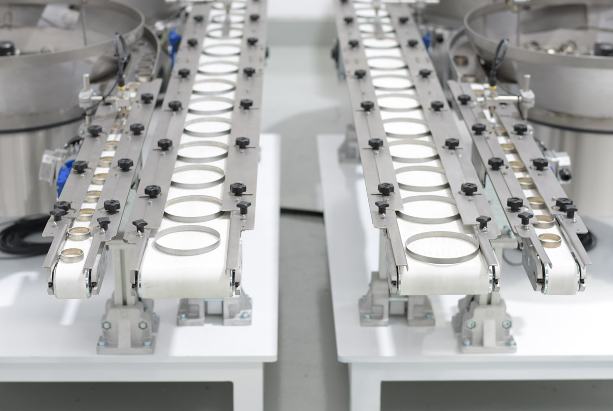Conjunto de posicionadores dispensadores vibratorios para el posicionamiento automatizado de aros metalicos o collarines vista salida producto